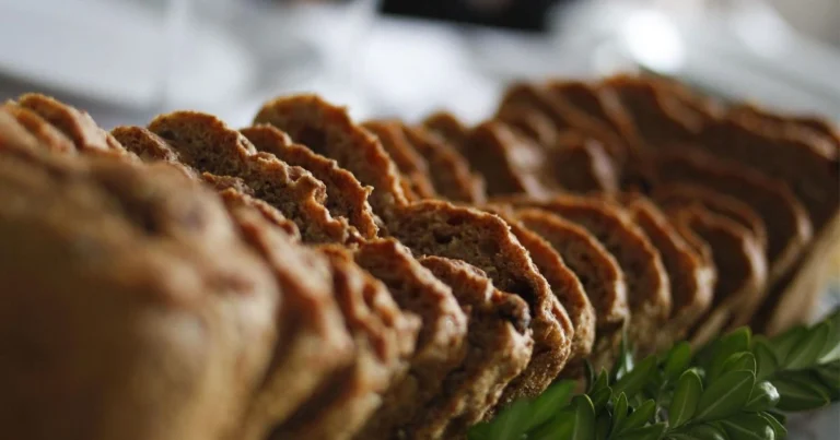 Freshly baked no sugar banana bread made with whole wheat flour, ripe bananas, and dark chocolate chips, sliced on a wooden board for a healthy low sugar banana loaf.